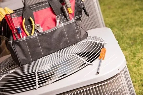 Tool bag placed on outdoor AC condenser unit