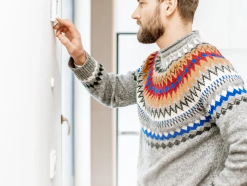 Man adjusting home thermostat for temperature control