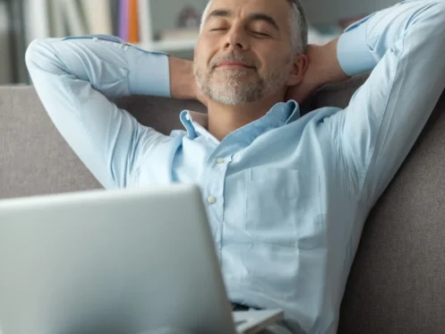 Happy man relaxing on couch in cool comfortable home